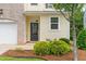 Close up of a townhome with brick, siding and a mulched garden surrounding the front entrance at 1007 Epiphany Rd, Morrisville, NC 27560