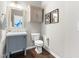 Stylish half bathroom featuring a vanity with storage and contemporary decor with hardwood flooring at 1007 Epiphany Rd, Morrisville, NC 27560