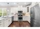 Kitchen with stainless steel appliances, white cabinets, hardwood floors, and quartz countertops at 1007 Epiphany Rd, Morrisville, NC 27560