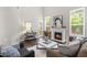 Bright living room featuring a fireplace, tall windows, and stylish furnishings at 1007 Epiphany Rd, Morrisville, NC 27560