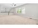 Bright, open loft space with plush carpeting, neutral walls, and large windows offering ample natural light at 1007 Epiphany Rd, Morrisville, NC 27560