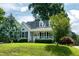 Inviting home with a charming front porch, surrounded by lush greenery and mature trees at 101 Stefi Ct, Garner, NC 27529