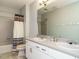 Bathroom with double sink vanity, large mirror, and tub with colorful shower curtain at 10101 Daviton Ct, Raleigh, NC 27615