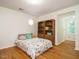 Bedroom with hardwood floors, window view, and hardwood bookshelf at 10101 Daviton Ct, Raleigh, NC 27615