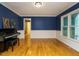 Dining room with half blue walls, hardwood floors, and a piano at 10101 Daviton Ct, Raleigh, NC 27615