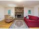 Bright living room with hardwood floors, a stone fireplace, and a red sofa at 10101 Daviton Ct, Raleigh, NC 27615