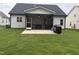 Back exterior featuring a screened-in porch, patio, and spacious backyard at 108 Sweetbay Park, Youngsville, NC 27596