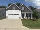 Charming home featuring white siding, stone accents, a two-car garage, and a well-manicured lawn at 108 Sweetbay Park, Youngsville, NC 27596