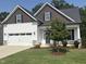 Charming home featuring white siding, stone accents, a two-car garage, and a well-manicured lawn at 108 Sweetbay Park, Youngsville, NC 27596