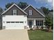 Charming home featuring white siding, stone accents, a two-car garage, and a well-manicured lawn at 108 Sweetbay Park, Youngsville, NC 27596