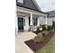 Inviting front porch featuring stone pillars, tasteful landscaping, and a beautiful front door with wreath at 108 Sweetbay Park, Youngsville, NC 27596