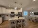 Bright kitchen featuring a large island, granite countertops, stainless steel appliances, and modern pendant lighting at 108 Sweetbay Park, Youngsville, NC 27596