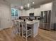 Bright kitchen featuring a large island, granite countertops, stainless steel appliances, and modern pendant lighting at 108 Sweetbay Park, Youngsville, NC 27596