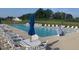 Community pool area with tables, chairs, umbrellas and lounge chairs for residents to relax and enjoy at 108 Sweetbay Park, Youngsville, NC 27596