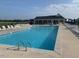 Large community swimming pool with chairs and umbrellas offering a relaxing outdoor space for residents at 108 Sweetbay Park, Youngsville, NC 27596