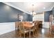 Formal dining room features wainscoting, a wooden dining table, and a decorative chandelier at 10847 Bedfordtown Dr, Raleigh, NC 27614