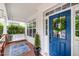 Inviting porch showcasing a swing, blue front door with wreath, and a decorative rug and plant at 10847 Bedfordtown Dr, Raleigh, NC 27614