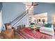 Open-concept living room with a staircase, a comfortable sofa, and a view into the kitchen at 10847 Bedfordtown Dr, Raleigh, NC 27614