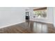 Open living room with hardwood floors, large windows, and view of a front porch at 10847 Bedfordtown Dr, Raleigh, NC 27614