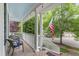 Relaxing back porch with white columns, chairs, an American flag and string lights at 10859 Bedfordtown Dr, Raleigh, NC 27614