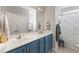 Bathroom with a double vanity sink, blue cabinets and colorful shower curtain at 10859 Bedfordtown Dr, Raleigh, NC 27614
