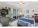 Cozy bedroom featuring a ceiling fan, large windows, and blue accents throughout at 10859 Bedfordtown Dr, Raleigh, NC 27614