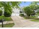 Exterior view of the two-story house with a three car garage and mature trees at 10859 Bedfordtown Dr, Raleigh, NC 27614