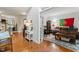 Bright hallway with hardwood floors leading to a home office, living space and staircase at 10859 Bedfordtown Dr, Raleigh, NC 27614