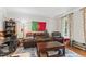 Cozy living room featuring a comfortable brown leather sofa, armchair, and decorative elements at 10859 Bedfordtown Dr, Raleigh, NC 27614