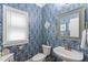 Charming powder room with unique blue patterned wallpaper at 10859 Bedfordtown Dr, Raleigh, NC 27614
