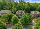 Aerial view of a traditional brick home surrounded by mature trees in a quiet, wooded neighborhood at 109 Aspenridge Dr, Holly Springs, NC 27540