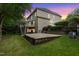 Exterior view of the house featuring a deck, and a stone patio surrounded by a well-maintained lawn at 109 Aspenridge Dr, Holly Springs, NC 27540