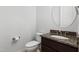 Bathroom with granite countertop on vanity, toilet, mirror, and wood floors at 109 Aspenridge Dr, Holly Springs, NC 27540