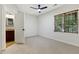 Carpeted bedroom with a ceiling fan and an open door leading to an ensuite bathroom at 109 Aspenridge Dr, Holly Springs, NC 27540
