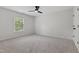 Bright bedroom with a large window, plush carpeting, and neutral paint to suit any décor at 109 Aspenridge Dr, Holly Springs, NC 27540