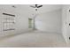 Large carpeted bedroom with two windows, a ceiling fan, and a vaulted ceiling at 109 Aspenridge Dr, Holly Springs, NC 27540