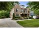 Elegant brick home featuring a lush lawn, manicured landscaping, a curved driveway, and an attached garage at 109 Aspenridge Dr, Holly Springs, NC 27540