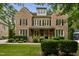 Charming brick two-story home featuring manicured landscaping, black shutters, and a covered front porch at 109 Aspenridge Dr, Holly Springs, NC 27540