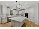 Bright kitchen with stainless appliances, quartz countertops, and large island with hardwood floor at 109 Aspenridge Dr, Holly Springs, NC 27540