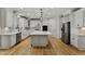 Bright kitchen with stainless appliances, quartz countertops, and large island with hardwood floor at 109 Aspenridge Dr, Holly Springs, NC 27540