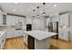 Bright kitchen with stainless appliances, quartz countertops, and large island with hardwood floor at 109 Aspenridge Dr, Holly Springs, NC 27540