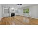 Living room with hardwood floors, fireplace, built in cabinets, and a ceiling fan at 109 Aspenridge Dr, Holly Springs, NC 27540