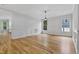Spacious living room with hardwood floors, white wainscoting, and a modern chandelier at 109 Aspenridge Dr, Holly Springs, NC 27540
