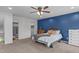 This bedroom features a ceiling fan, neutral carpet, a blue accent wall, and a full-size bed at 11 Stone Village Ct, Durham, NC 27704