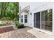 Back of home featuring sliding glass door and windows overlooking a well-maintained yard with brick patio at 11710 Mezzanine Dr # 101, Raleigh, NC 27614