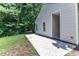Home's backyard featuring a concrete patio and a grassy area surrounded by trees at 1202 Kendall Dr, Durham, NC 27703