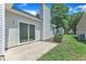 Back of the home showing a sliding glass door to the patio and a grassy yard at 1202 Kendall Dr, Durham, NC 27703