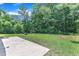 Large backyard featuring a concrete patio, well-maintained lawn, and mature trees, providing a serene outdoor space at 1202 Kendall Dr, Durham, NC 27703
