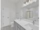 Bright bathroom features a double vanity, large mirror, and a glass shower with a garden tub in the background at 1202 Kendall Dr, Durham, NC 27703