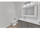 Modern bathroom featuring a sleek vanity with stone countertop, a white toilet and wood-look flooring at 1202 Kendall Dr, Durham, NC 27703